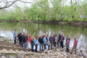 Watershed Project volunteers pose for group photo on river bank